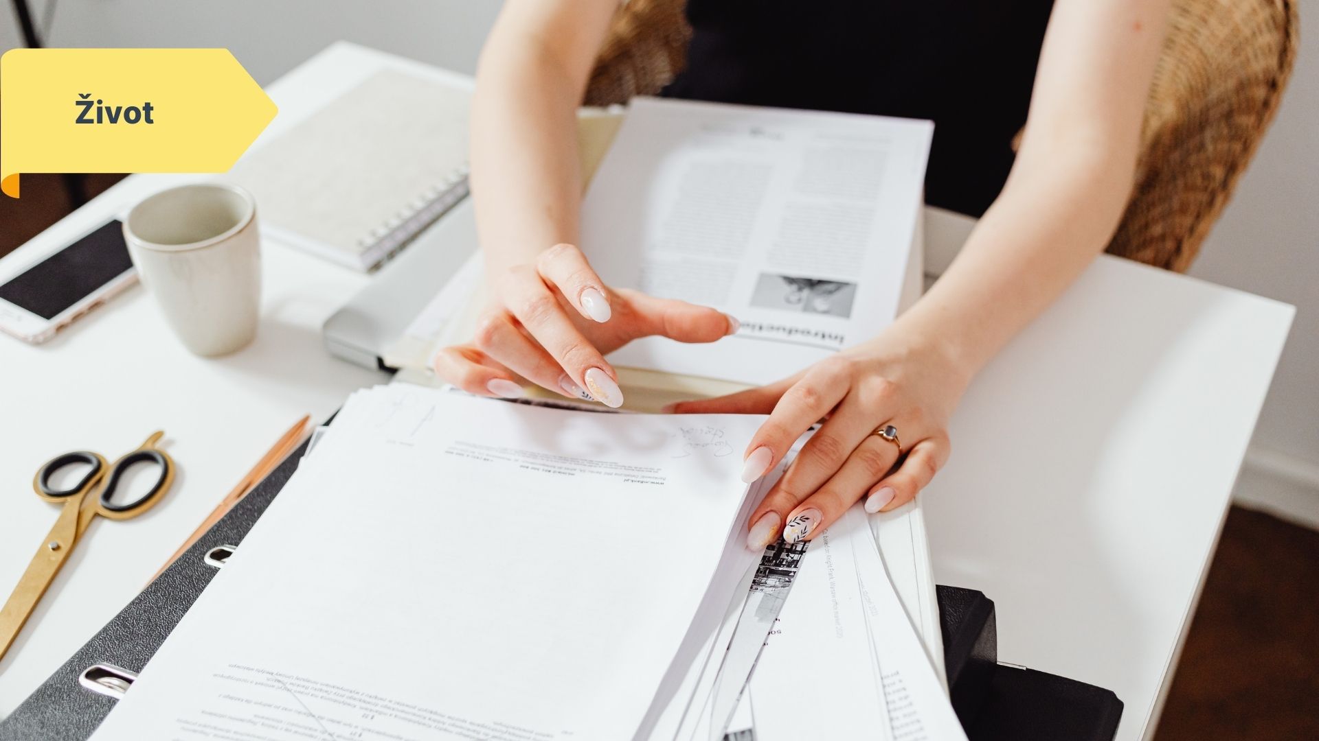 Žena organizuje papíry a smlouvy na psacím stole do šanonu.